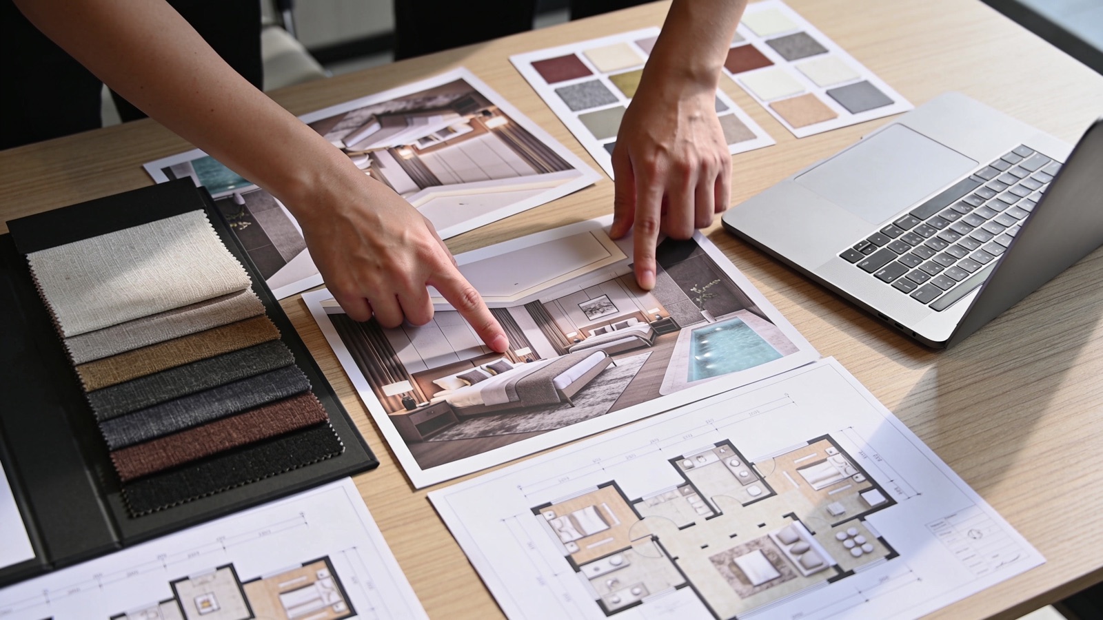 Projekt-Briefing im Hotel: Interior-Renderings, Stoffmuster und Grundrisse auf dem Tisch
